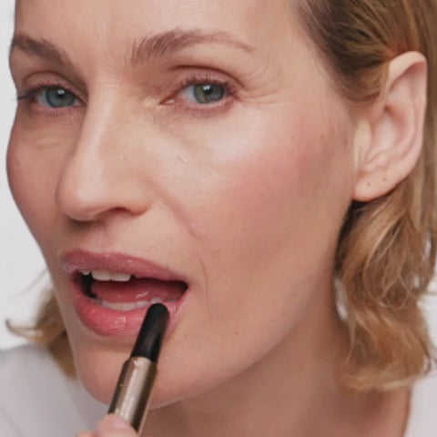 Vrouw brengt de Mini Hydrating Lip Tint in Dusty Rose aan voor een natuurlijke roze, gehydrateerde lipfinish.