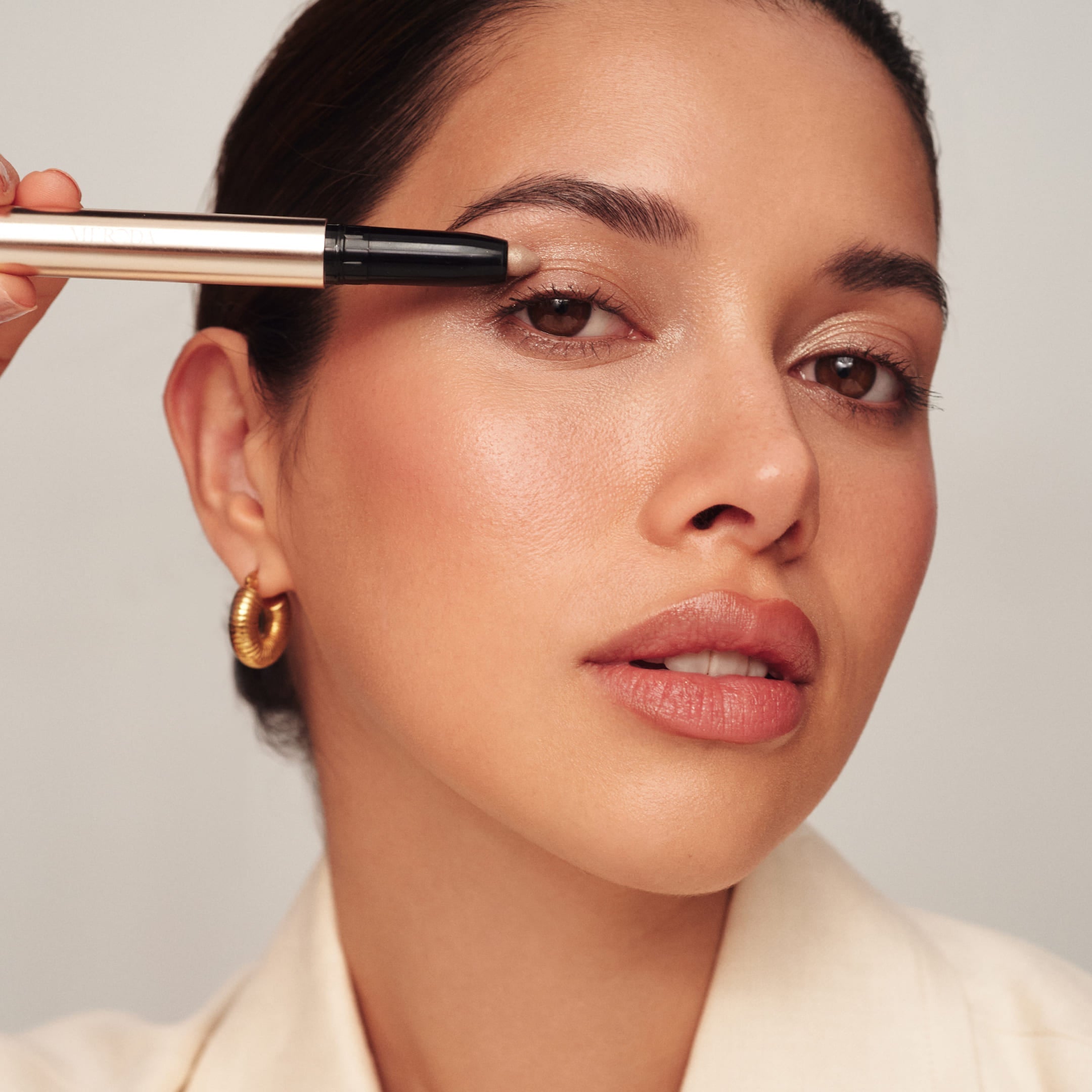 Model brengt de Meroda Mini Eye Shimmer Set in de tint Champagne aan op het ooglid