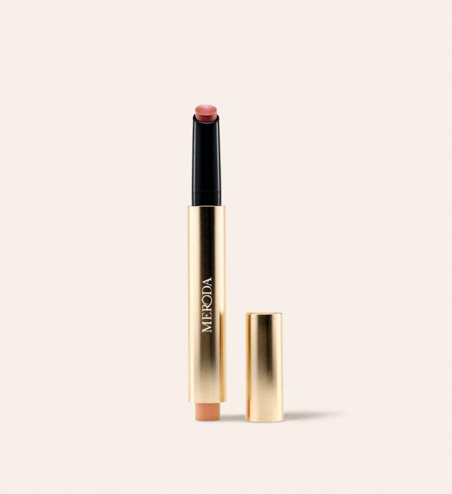 Hydrating Lip Tint in Honey Beige: een slanke gouden pen met warme nude balsem en losse dop op een crème achtergrond.