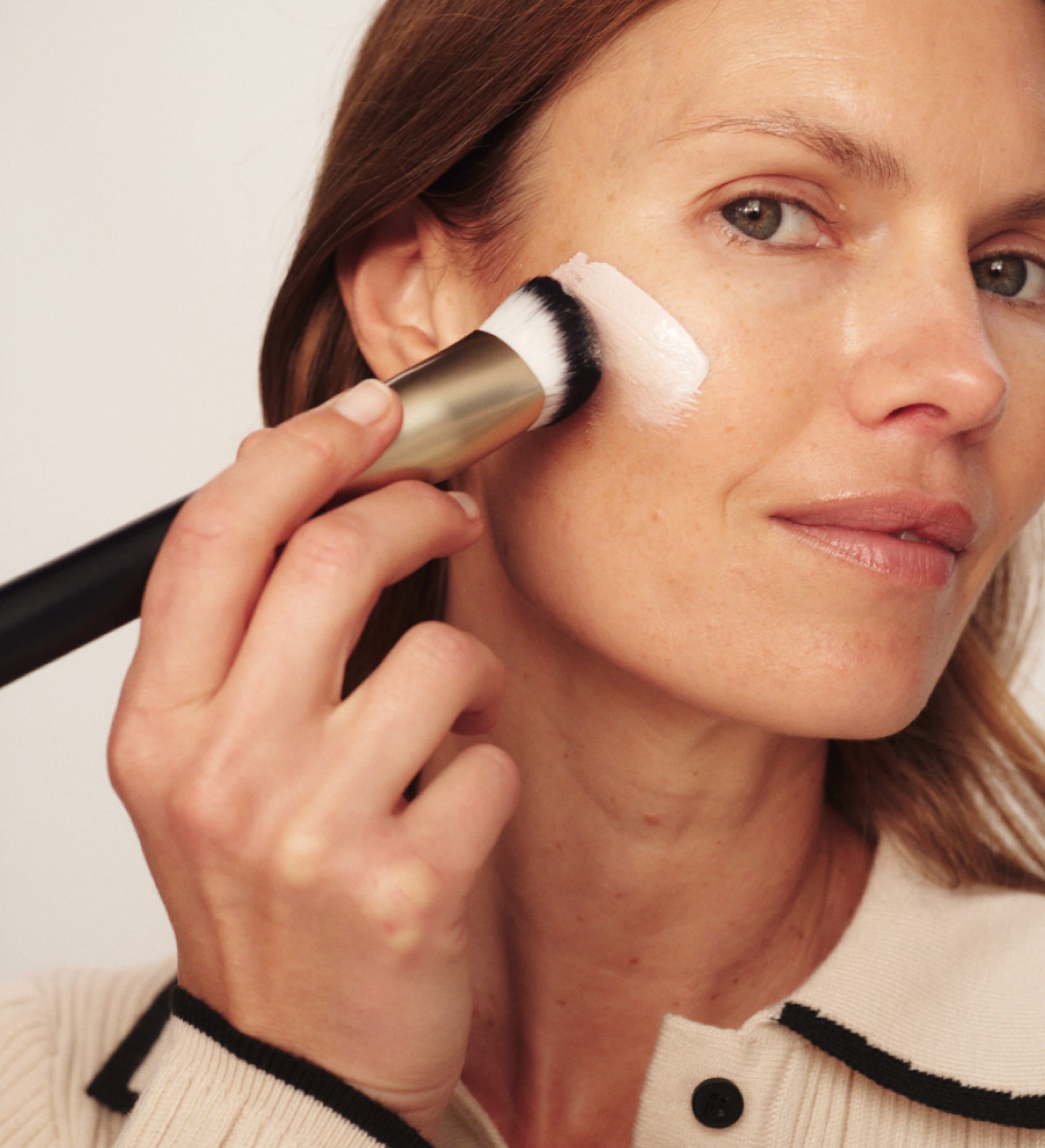 Vrouw brengt Meroda Cosmetics Changing Foundation aan met de Essential Brush voor een natuurlijke look