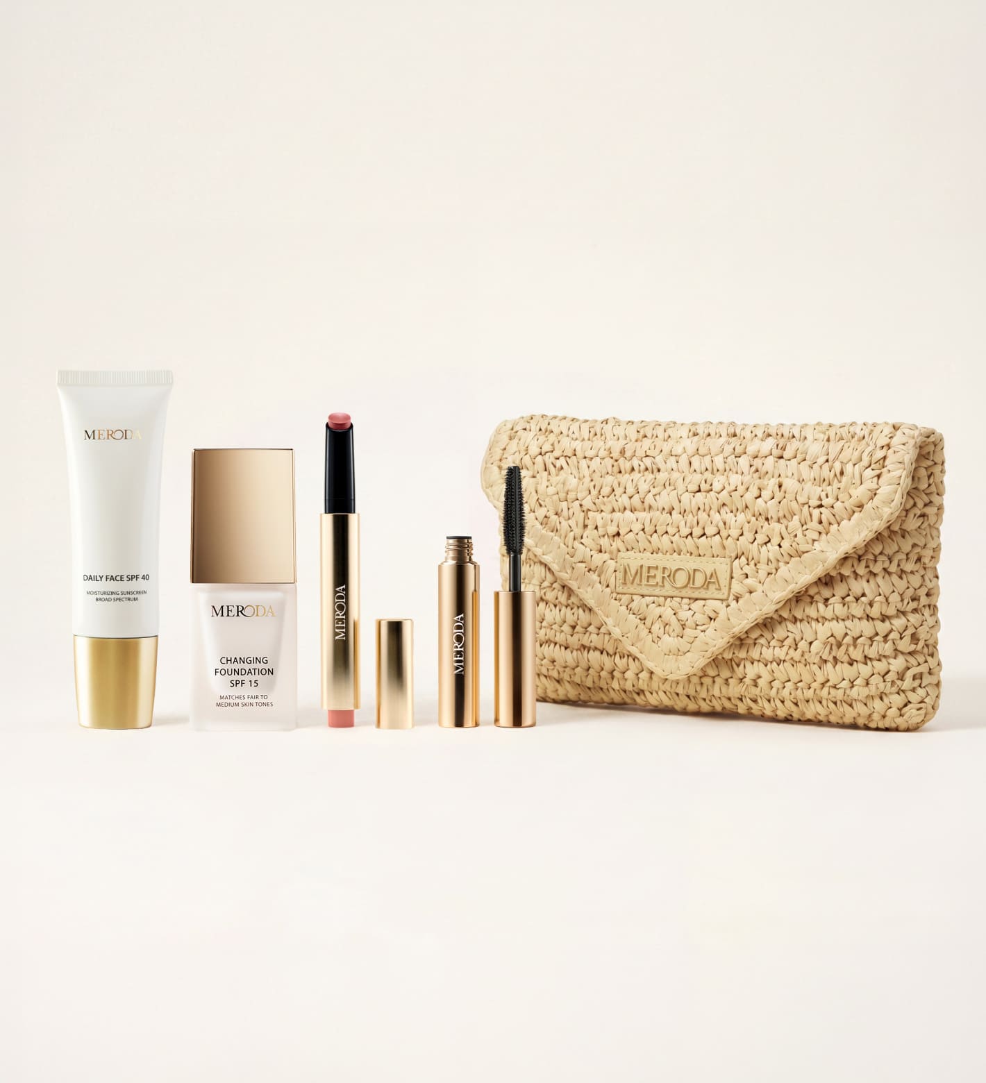 Summer Travel Icons set met Daily Face SPF 40, Changing Foundation, lip tint, mascara en een beige geweven clutch.