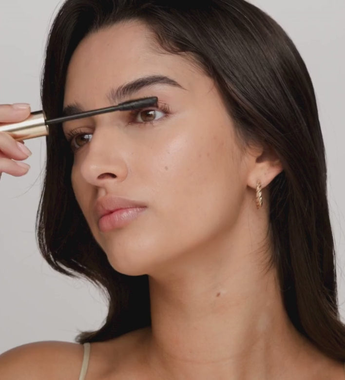Model brengt Gilded Lashes Mascara aan voor gedefinieerde, volle wimpers.